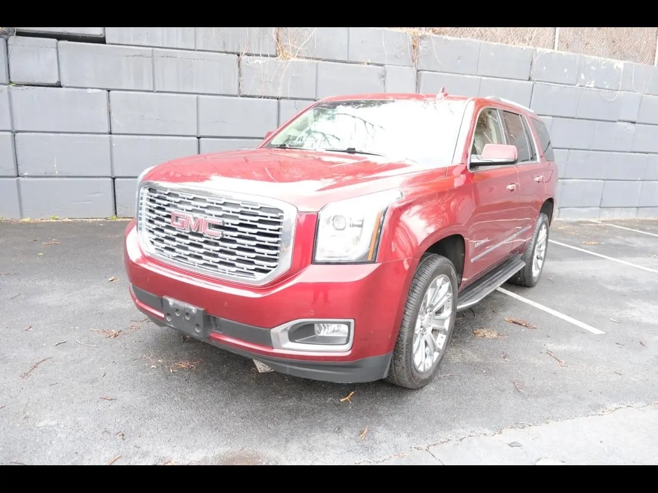 Red GMC Yukon before enhancement in harsh outdoor light